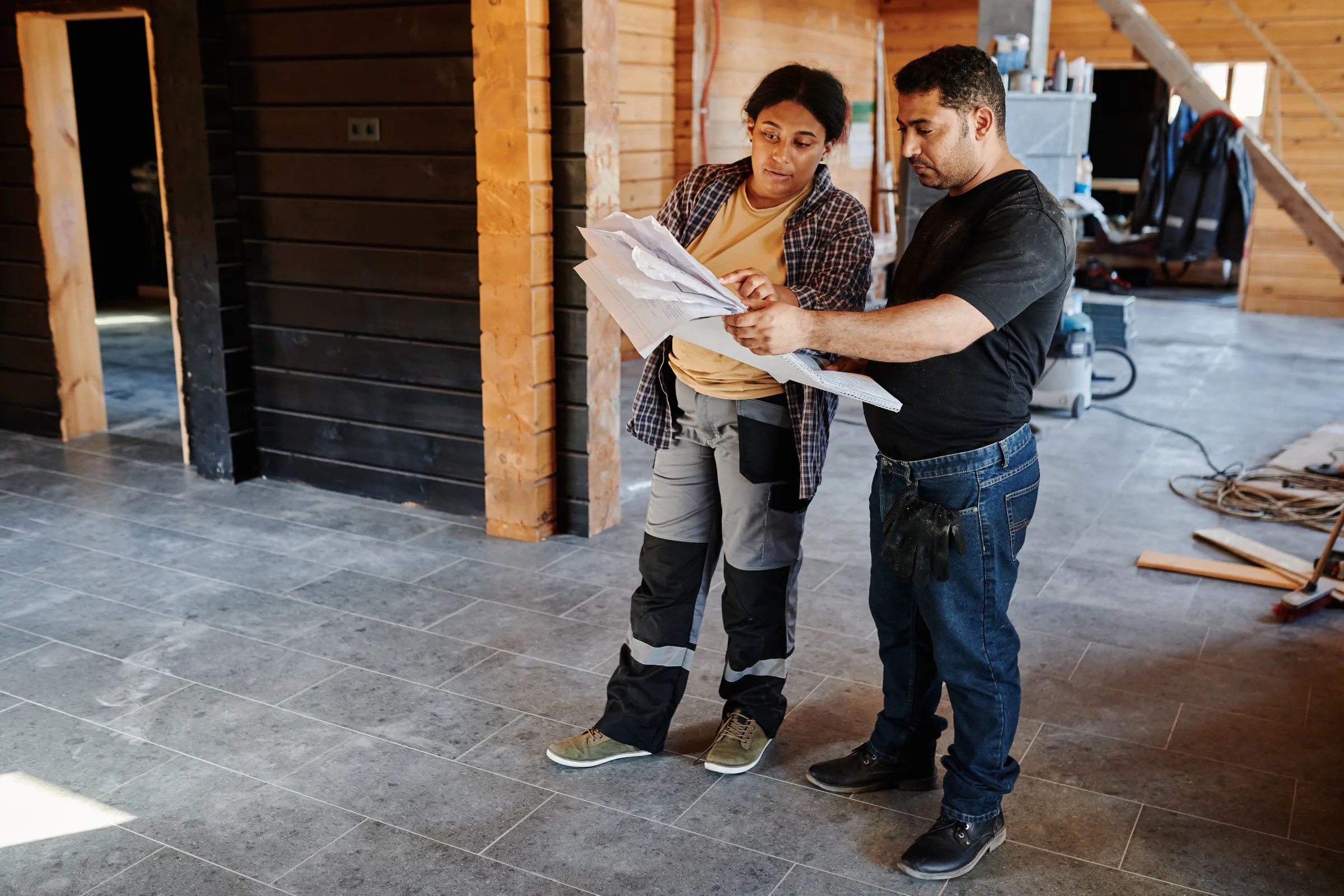 Two construction professionals reviewing plans at an active job site