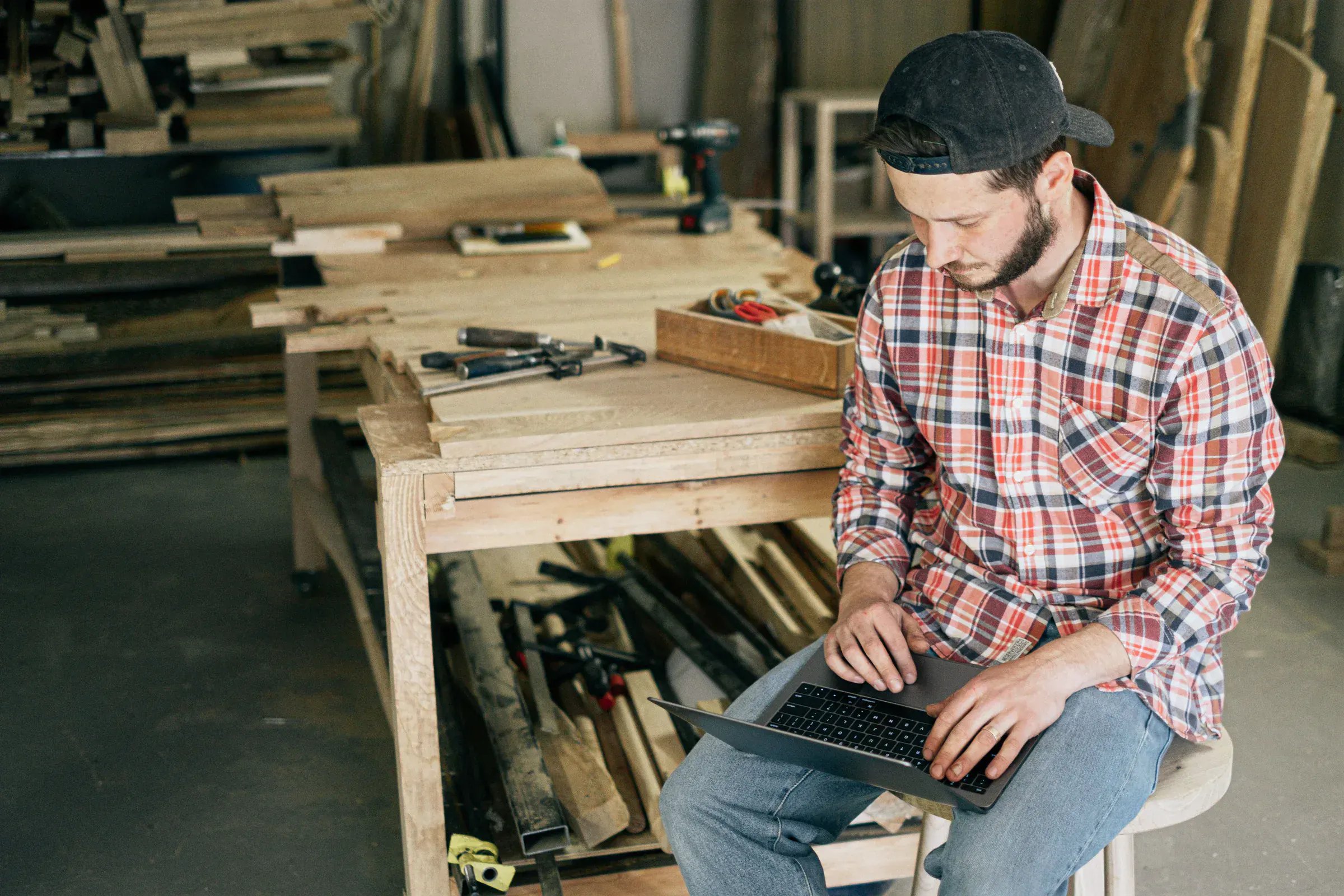 A small-business owner working through paperwork alone at his workshop bench