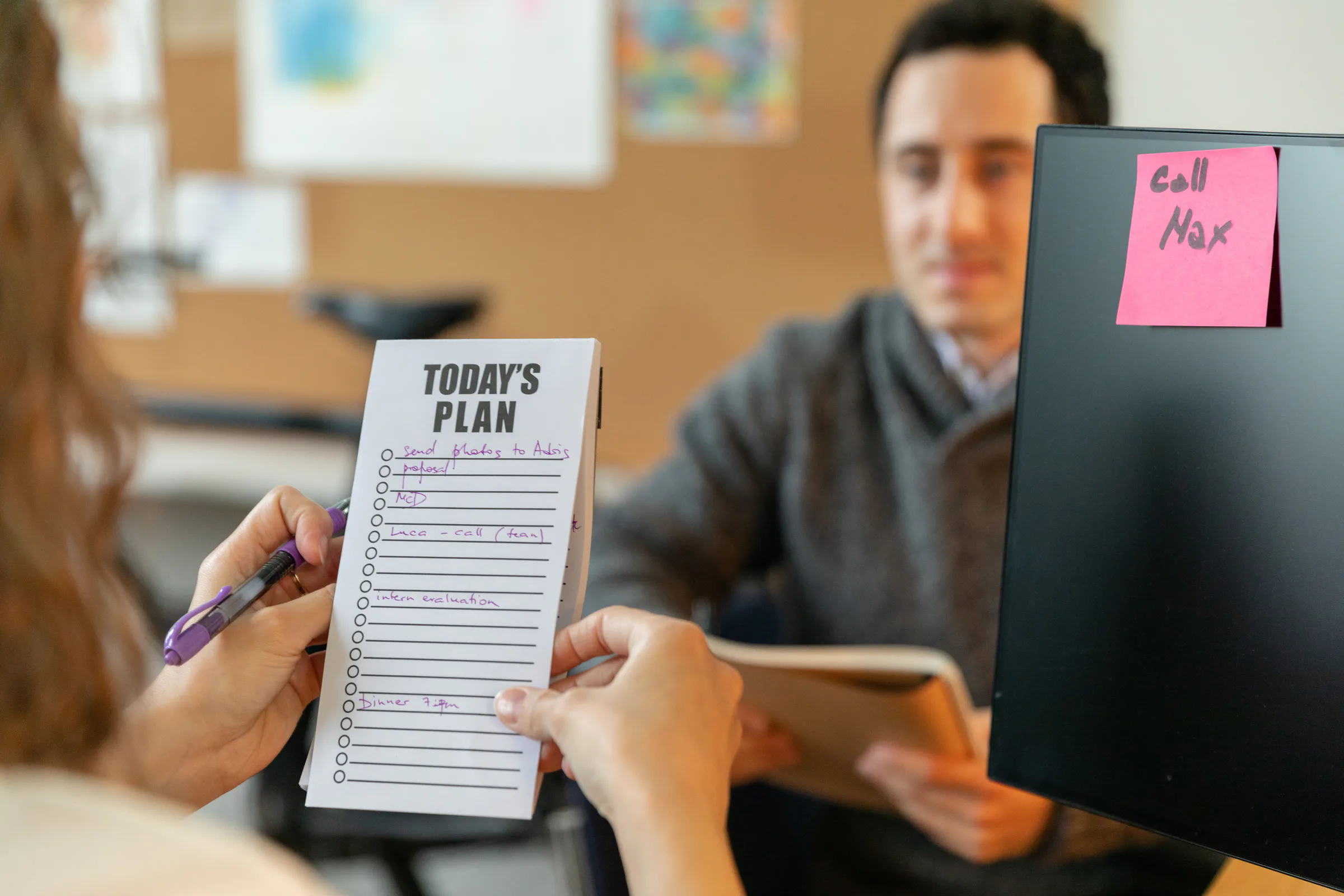 Two colleagues assigning work and roles with a shared planning board