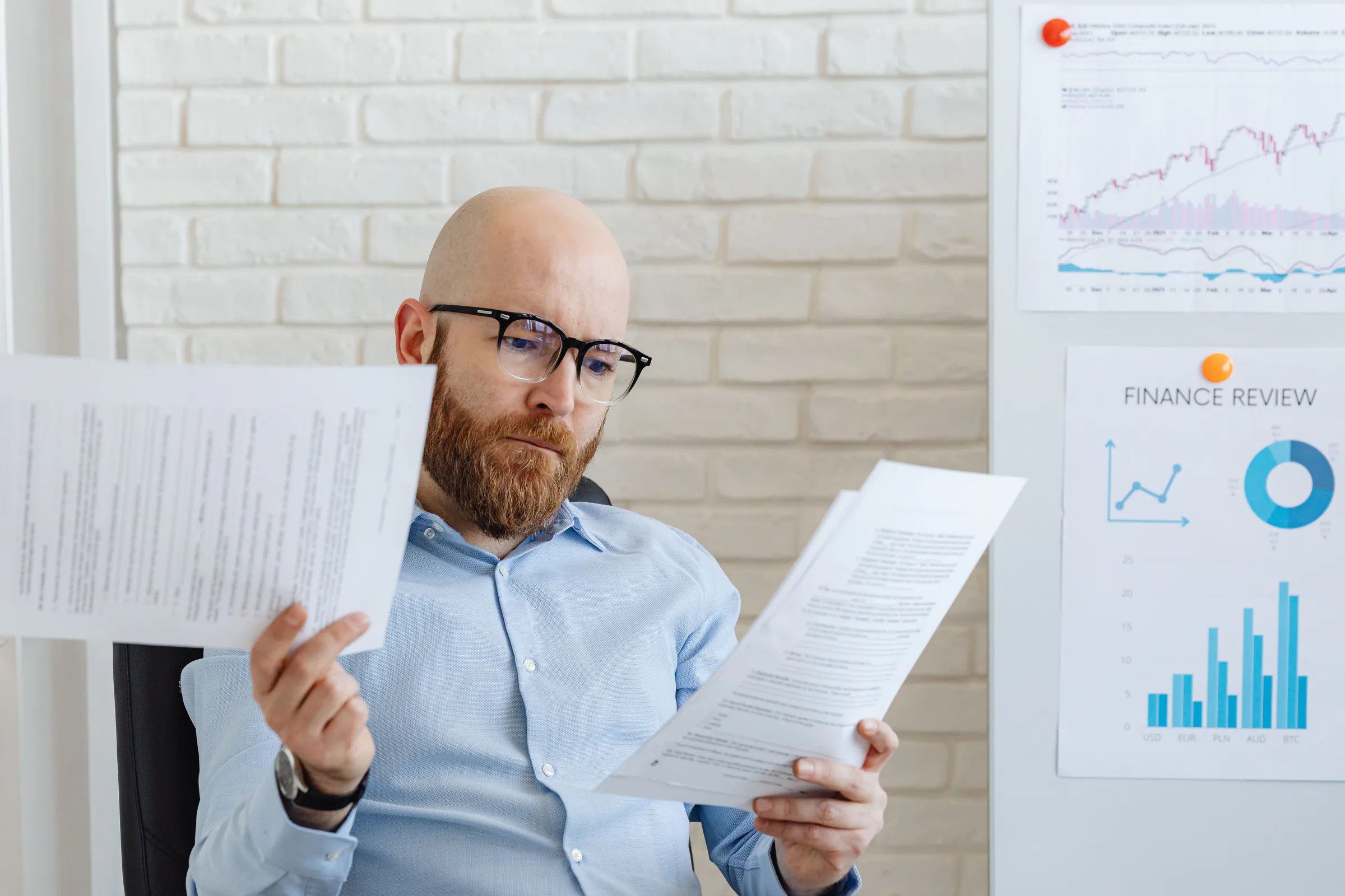 A business owner reviewing operating reports at his desk