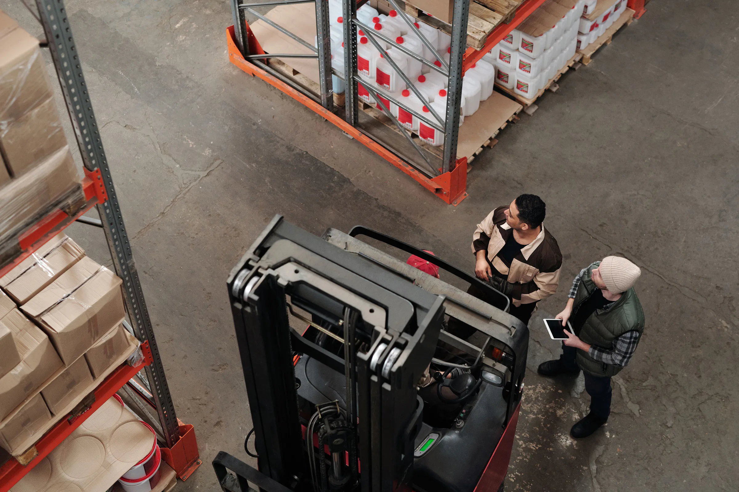 A field team reviewing logistics together beside warehouse equipment